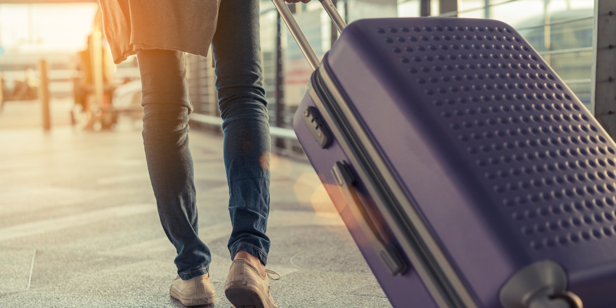 woman traveling in airport with suitcase